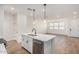 Open concept kitchen featuring an island with a sink, flowing into the living area with wood floors at 2658 S Sulley Dr # 102, Gilbert, AZ 85295