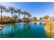 A tranquil pond with water features is framed by palm trees and well-maintained landscaping, with residential buildings in the background at 2658 S Sulley Dr # 102, Gilbert, AZ 85295
