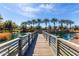 Scenic view from a wooden bridge stretching across a calm pond reflecting the bright blue sky with scattered clouds at 2658 S Sulley Dr # 102, Gilbert, AZ 85295