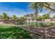 A peaceful pond with fountain features is complemented by palm trees and lush grass, set against a backdrop of community residences at 2658 S Sulley Dr # 102, Gilbert, AZ 85295