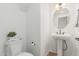 A white powder room includes a pedestal sink and accent mirror at 2658 S Sulley Dr # 102, Gilbert, AZ 85295