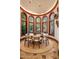 Bright dining area with a round wood table, seating, and curved windows that offer views of the garden at 26796 N 98Th Way, Scottsdale, AZ 85262