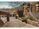 A home featuring stone architecture, a private driveway, a garage and lush desert landscaping at 26796 N 98Th Way, Scottsdale, AZ 85262