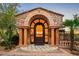 Grand entryway featuring a stone archway with stately pillars and beautiful landscaping at 26796 N 98Th Way, Scottsdale, AZ 85262