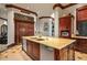 Kitchen featuring a large island with bar seating, dual sinks, wooden cabinets and views of the outdoors at 26796 N 98Th Way, Scottsdale, AZ 85262