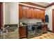 A modern laundry room featuring wood cabinets, stone countertop and high-end washer and dryer at 26796 N 98Th Way, Scottsdale, AZ 85262