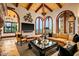 Beautiful living room with an arched ceiling, stone fireplace, comfortable seating, and outdoor views at 26796 N 98Th Way, Scottsdale, AZ 85262