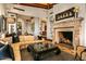 Spacious living room with a large stone fireplace, and comfortable furnishings with a view of the kitchen at 26796 N 98Th Way, Scottsdale, AZ 85262