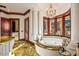 Elegant main bathroom featuring a corner bathtub and decorative tile flooring at 26796 N 98Th Way, Scottsdale, AZ 85262