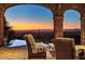 Patio with scenic views, stone arches, stylish outdoor furniture, and access to the pool at 26796 N 98Th Way, Scottsdale, AZ 85262