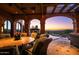 Outdoor patio features stunning sunset views, stone arches, tile flooring, and seating area at 26796 N 98Th Way, Scottsdale, AZ 85262