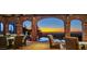 Outdoor patio features stunning sunset views, stone arches, tile flooring, and seating area at 26796 N 98Th Way, Scottsdale, AZ 85262