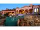 Beautiful backyard pool with waterfall feature and elevated lounge area with architectural arches at 26796 N 98Th Way, Scottsdale, AZ 85262
