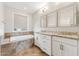 Bathroom featuring a soaking tub, double vanity with granite countertop, and decorative mirrors at 27420 N 170Th St, Rio Verde, AZ 85263