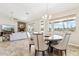 Open-concept dining area with elegant seating, seamlessly connects to the living room with fireplace and desert views at 27420 N 170Th St, Rio Verde, AZ 85263