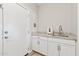 Functional laundry area featuring a sink, granite countertops, white cabinets, and modern fixtures at 27420 N 170Th St, Rio Verde, AZ 85263