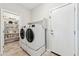 Well-equipped laundry room with modern washer and dryer set, storage shelves, and tiled floors at 27420 N 170Th St, Rio Verde, AZ 85263