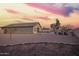 An appealing backyard with a desert landscape that includes a sandbox, firepit and sitting area for relaxing and entertaining at 30370 N Opal Dr, San Tan Valley, AZ 85143