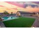 Backyard featuring artificial turf, sparkling pool, lounge chairs, and desert landscape, creating an inviting outdoor oasis at 30370 N Opal Dr, San Tan Valley, AZ 85143