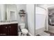 Bathroom featuring dark wood cabinets, granite countertop, decorative shelving, and shower-tub combo at 30370 N Opal Dr, San Tan Valley, AZ 85143