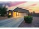 Single-story home at dusk features a two-car garage, desert landscaping, and a long driveway at 30370 N Opal Dr, San Tan Valley, AZ 85143