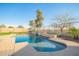 Enjoy this stunning pool with stone accents and professional landscaping under a beautiful, clear sky at 30370 N Opal Dr, San Tan Valley, AZ 85143