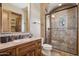 Bathroom features a glass enclosed shower, countertop with basin, and a vanity with storage at 3312 N 89Th Pl, Mesa, AZ 85207