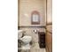 Powder bathroom with a small window, dark wood accent cabinet, and tile flooring at 3312 N 89Th Pl, Mesa, AZ 85207