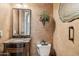 Elegant powder room boasting decorative wall accents, a granite vanity, and a modern toilet at 3312 N 89Th Pl, Mesa, AZ 85207