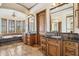 Luxurious bathroom with dual vanities, travertine tile floor, and soaking tub with garden view windows at 3312 N 89Th Pl, Mesa, AZ 85207