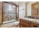 Bathroom featuring a glass-enclosed tub/shower with neutral tile, vanity with tile countertop, and toilet at 3312 N 89Th Pl, Mesa, AZ 85207