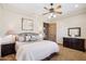 This bedroom boasts a ceiling fan, bedside tables, and a decorative painting at 3312 N 89Th Pl, Mesa, AZ 85207