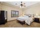 Bedroom with a ceiling fan, shuttered windows, bed, and a sitting bench at 3312 N 89Th Pl, Mesa, AZ 85207