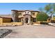 Exterior of home featuring stone accents, arched entry, and a paved driveway leading to a grand entrance at 3312 N 89Th Pl, Mesa, AZ 85207