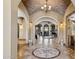 Grand foyer with brick archway, decorative tile inlay, and elegant chandelier at 3312 N 89Th Pl, Mesa, AZ 85207