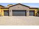 Spacious garage with three doors and stone accents, offering ample parking and storage at 3312 N 89Th Pl, Mesa, AZ 85207