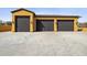 Spacious three-car garage providing ample parking and storage, enhanced by stylish exterior lighting at 3312 N 89Th Pl, Mesa, AZ 85207