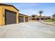 Exterior view of the three car garage, situated next to the main home with circular driveway at 3312 N 89Th Pl, Mesa, AZ 85207