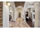 Long hallway featuring archways, stone floors, and elegant lighting fixtures at 3312 N 89Th Pl, Mesa, AZ 85207