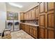 The laundry room offers generous cabinet space, tile floor, and front-loading washer and dryer at 3312 N 89Th Pl, Mesa, AZ 85207