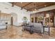 Spacious living room boasting stone flooring, custom wood-beamed ceilings, and a large stone fireplace at 3312 N 89Th Pl, Mesa, AZ 85207