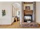 Cozy living room with stone fireplace, carpet flooring, and a view into an office space at 3312 N 89Th Pl, Mesa, AZ 85207