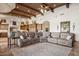 Expansive living area showcasing a plush sofa, patterned rug, and seamless flow to the kitchen at 3312 N 89Th Pl, Mesa, AZ 85207