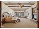 Spacious main bedroom with exposed ceiling beams, fireplace, and plush carpet flooring at 3312 N 89Th Pl, Mesa, AZ 85207