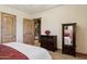 Main bedroom featuring wood doors and furniture and a view to an ensuite bathroom at 3312 N 89Th Pl, Mesa, AZ 85207