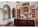 Well-appointed office featuring a wooden desk, built-in shelving, and brick archways at 3312 N 89Th Pl, Mesa, AZ 85207