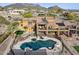 Aerial view of desert home featuring pool with diving board, and covered patio in a serene backyard setting at 3312 N 89Th Pl, Mesa, AZ 85207