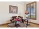 Cozy seating area featuring plush chairs, flowers, side table, and elegant window shutters at 3312 N 89Th Pl, Mesa, AZ 85207