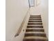 Carpeted staircase featuring a wooden handrail and bright lighting leading to the upper level at 3312 N 89Th Pl, Mesa, AZ 85207