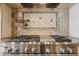 Close up of the stainless steel stovetop with pot filler and decorative tile backsplash at 3312 N 89Th Pl, Mesa, AZ 85207